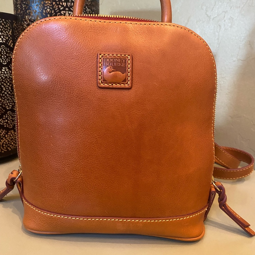 Dooney & Bourke small zip pod backpack in the color natural.